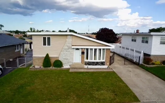 a view of a house with a yard and sitting area