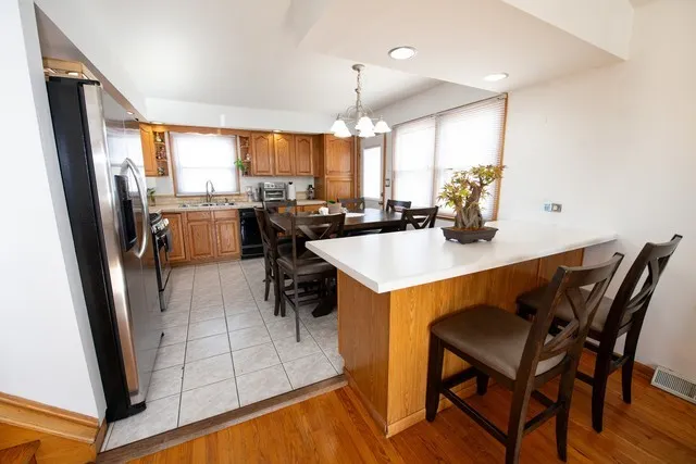 a kitchen with a table chairs refrigerator and microwave
