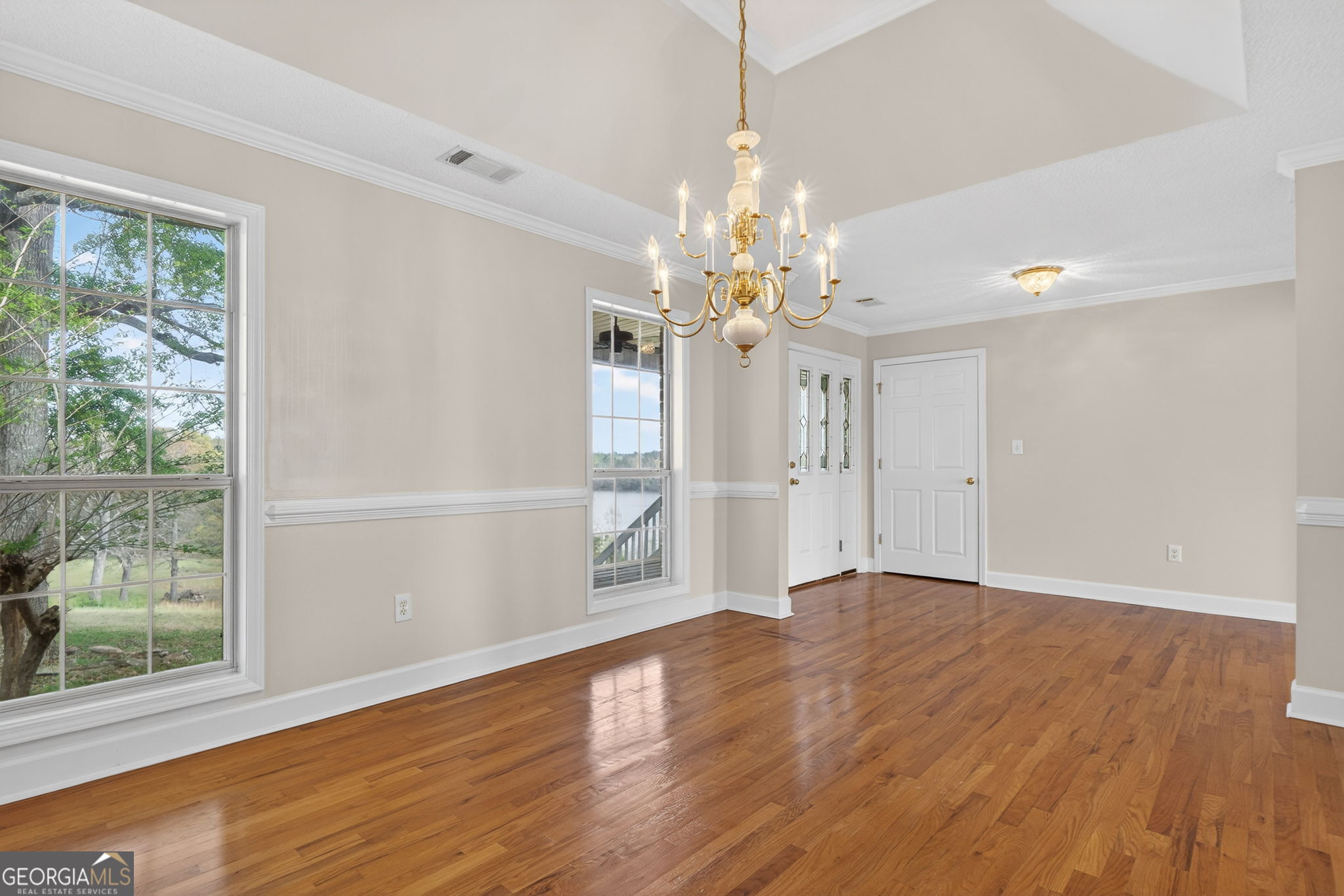955 Mocassin Gap Road Locust Grove, GA 30248 - Photo 8 of 59 a view of an empty room with wooden floor and a window