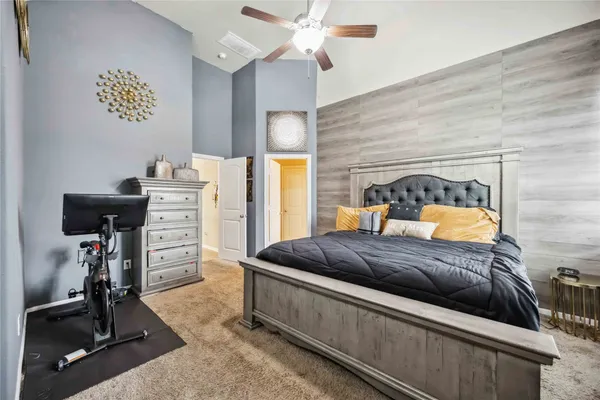 a bedroom with a bed and a flat tv screen on the dresser