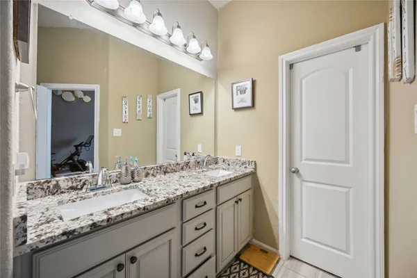 a bathroom with a granite countertop sink a mirror and a shower