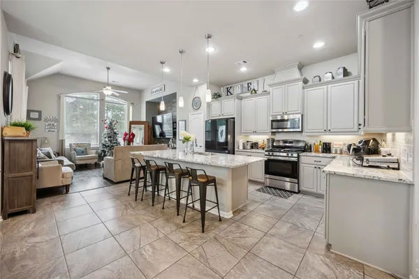 a large white kitchen with lots of counter space and stainless steel appliances