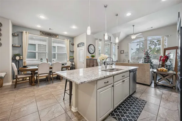 a kitchen with counter space appliances a sink and a living room view
