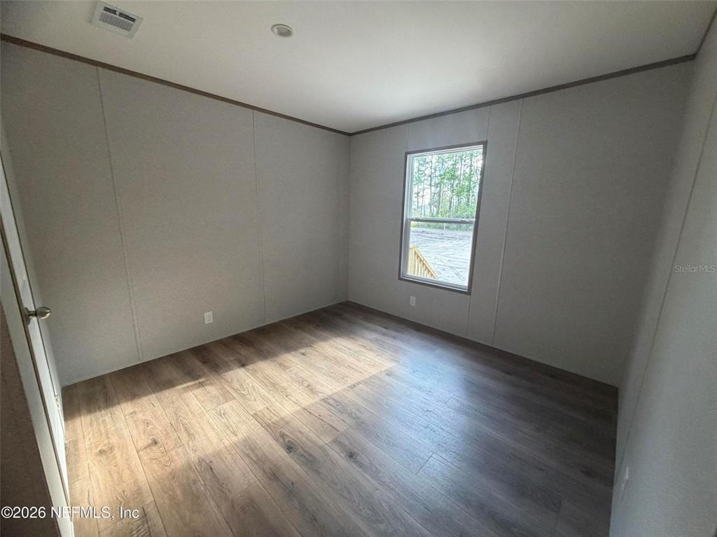 114 Nutmeg Trail Interlachen, FL 32148 - Photo 20 of 33 an empty room with wooden floor and windows