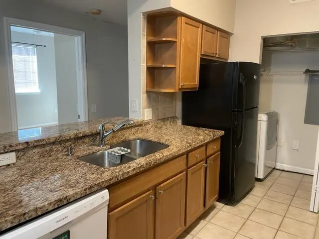 a kitchen with a sink refrigerator and cabinets