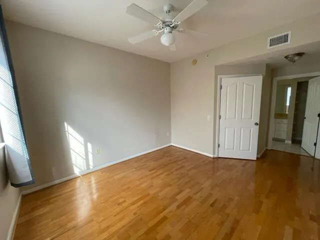 an empty room with wooden floor and windows
