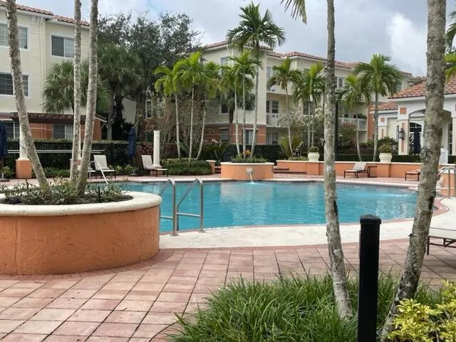 a view of swimming pool with lawn chairs and plants