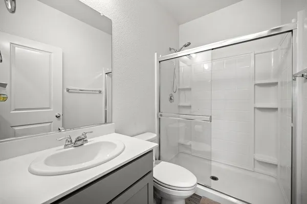 a bathroom with a sink a toilet and shower