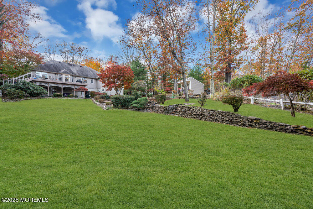 a view of a house with a big yard and large trees