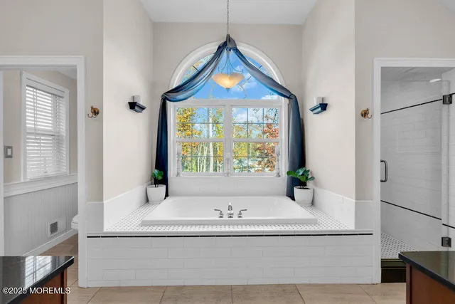 a spacious bathroom with a granite countertop tub sink and mirror