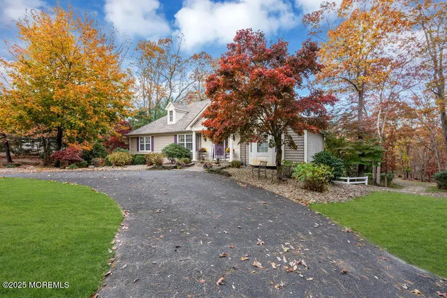 a front view of a house with a yard and tree s