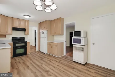 a kitchen with a refrigerator cabinets and wooden floor