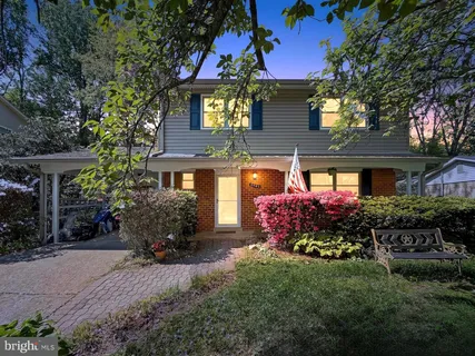 a front view of a house with a yard and potted plants