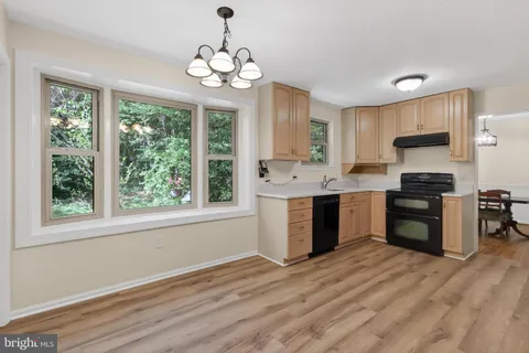 a kitchen with a refrigerator cabinets and wooden floor