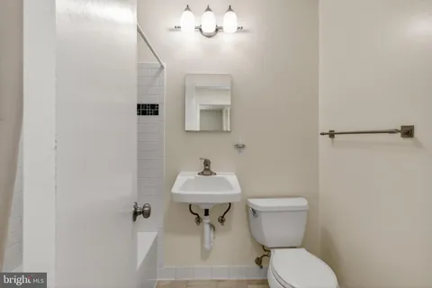 a bathroom with a toilet a sink and mirror