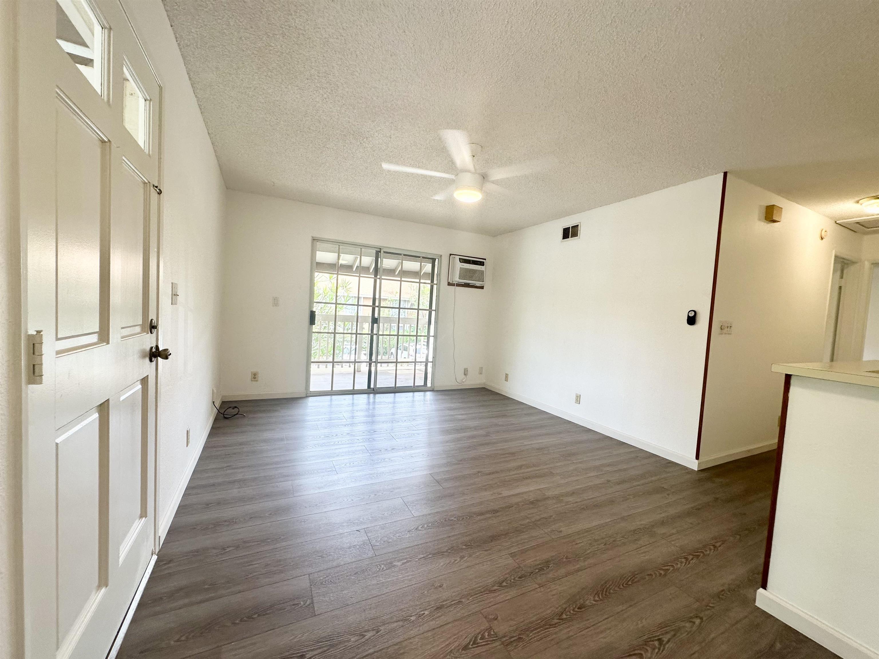 140 Uwapo Road, Unit 33201 Kihei, HI 96753 - Photo 4 of 13 an empty room with wooden floor and windows