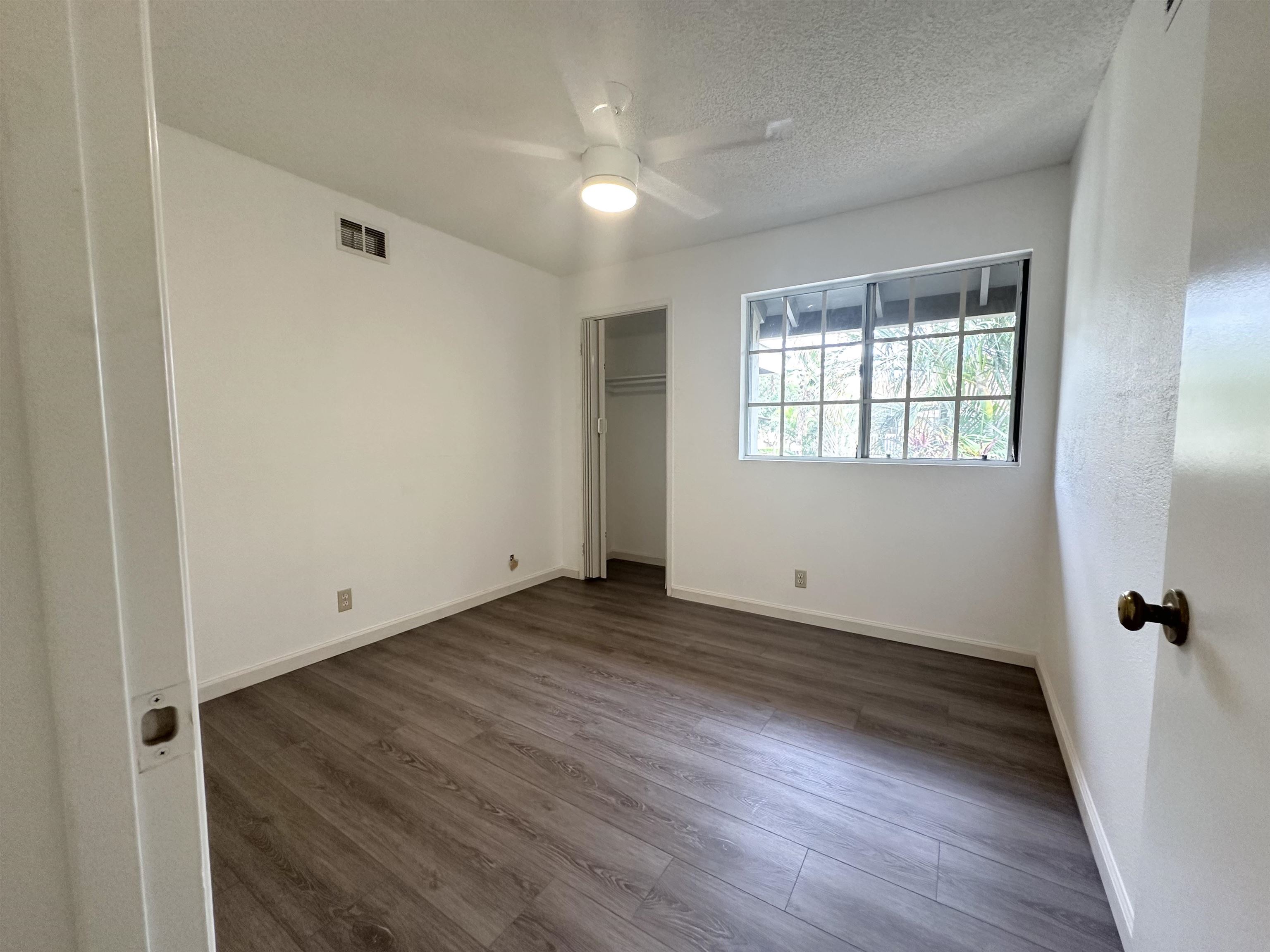 140 Uwapo Road, Unit 33201 Kihei, HI 96753 - Photo 6 of 13 an empty room with wooden floor and windows