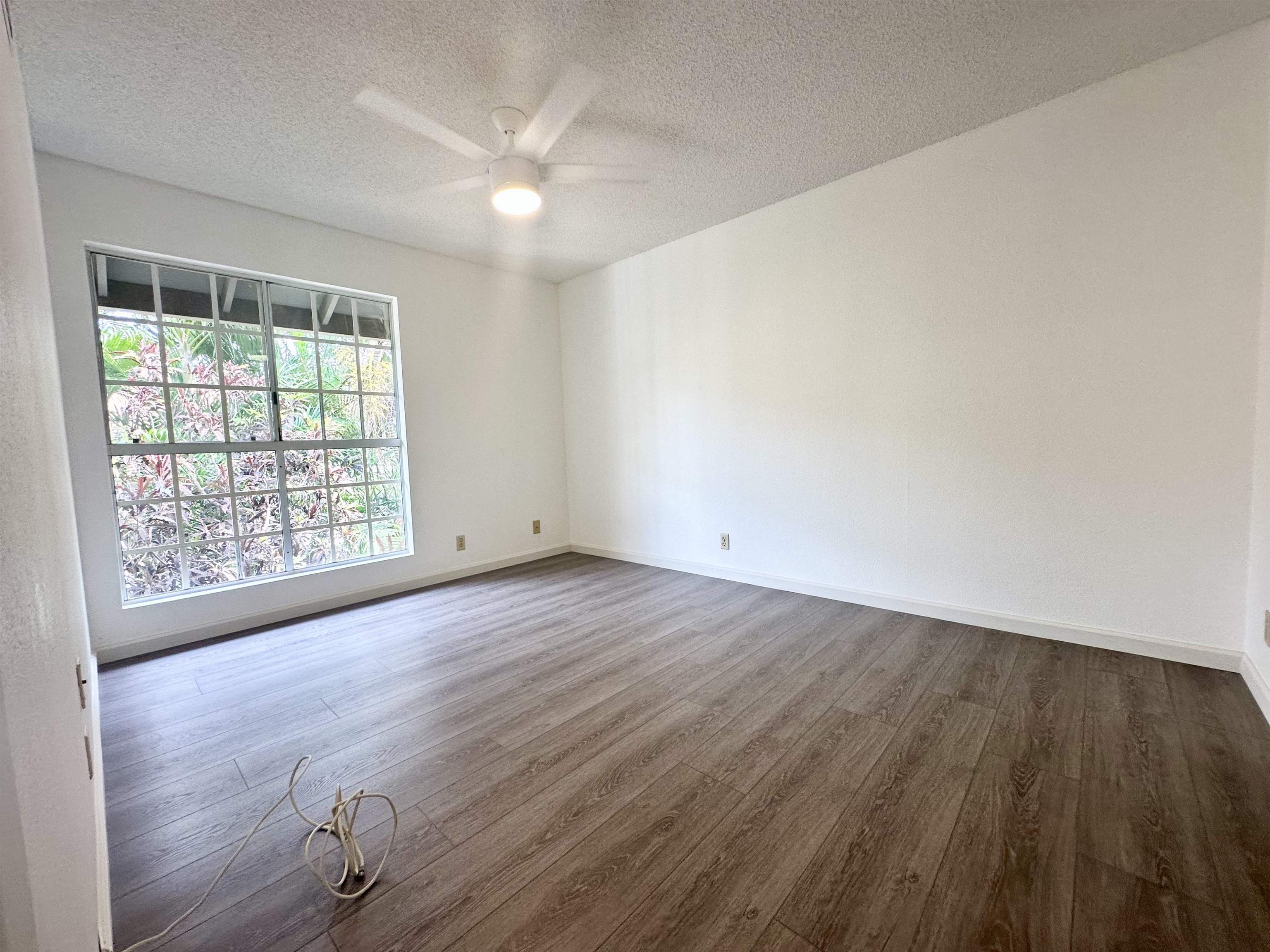 140 Uwapo Road, Unit 33201 Kihei, HI 96753 - Photo 8 of 13 an empty room with wooden floor and windows