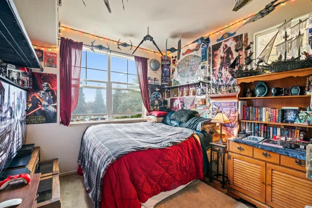 a bed sitting in a bedroom next to a large window