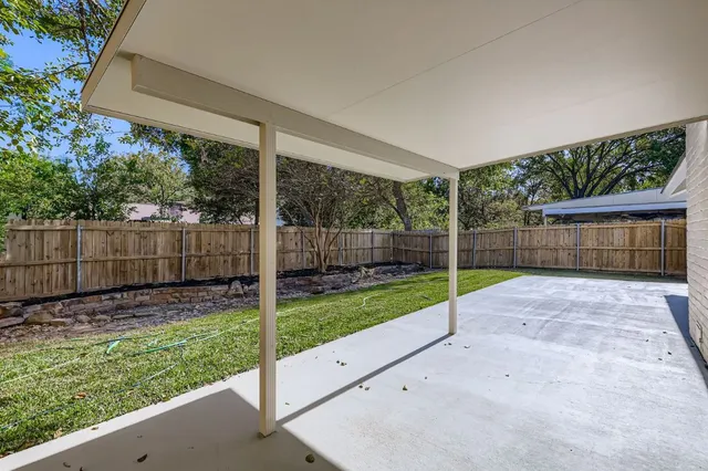 a view of a backyard with wooden fence