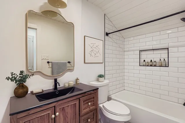 a bathroom with a toilet a sink and mirror