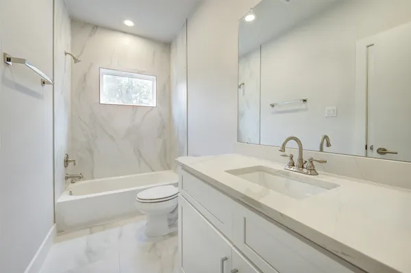 an empty room with a window and a ceiling fan