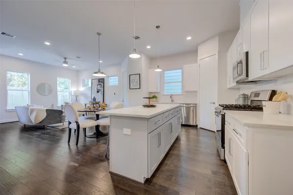 a kitchen with counter top space a sink appliances and cabinets
