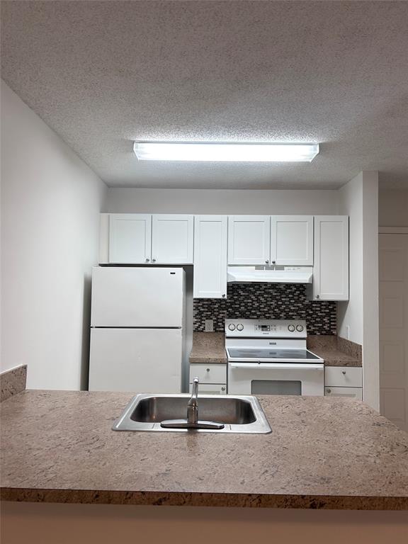 4481 West McNab Road, Unit 26 Pompano Beach, FL 33069 - Photo 8 of 13 a kitchen with granite countertop a sink and a stove top oven
