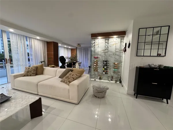 a living room with furniture a large window and a chandelier