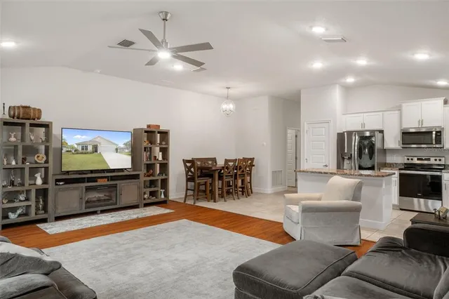 a kitchen with granite countertop a refrigerator stove and sink