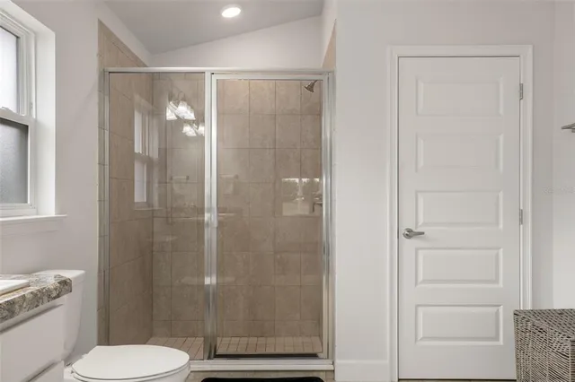a bathroom with a granite countertop sink a mirror and a toilet