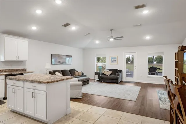 a living room with furniture and kitchen view