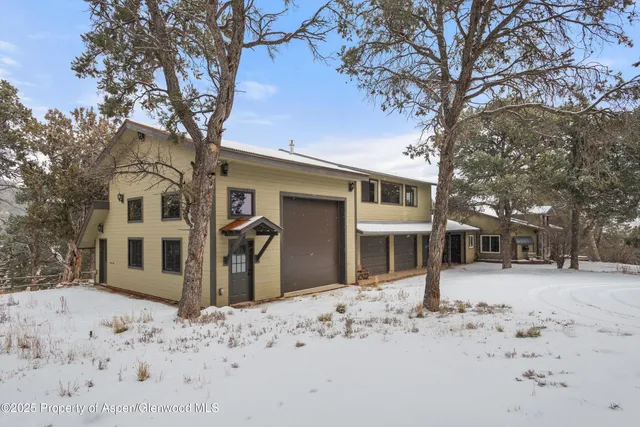 a front view of a house with a yard covered in snow