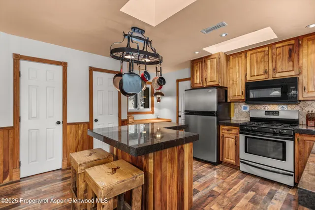 a kitchen with stainless steel appliances granite countertop a sink stove and refrigerator
