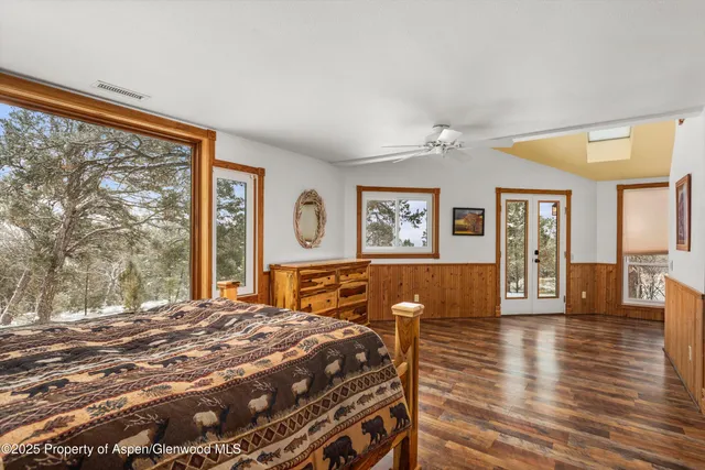 a bed sitting in a spacious bedroom next to a window