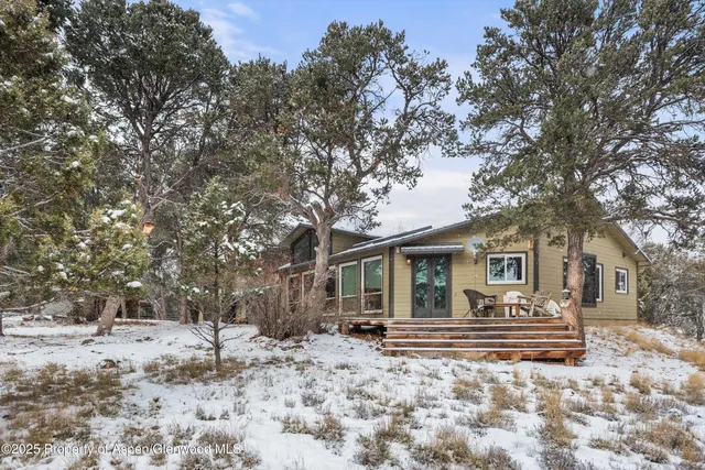 a front view of house with yard and trees in the background