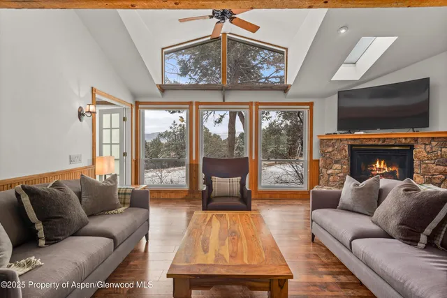a living room with furniture large windows and a flat screen tv