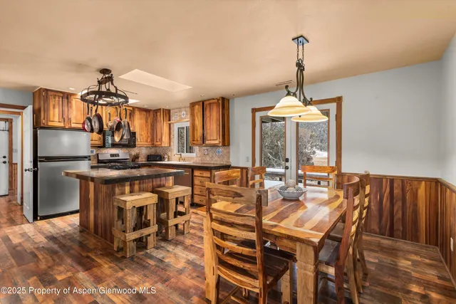 a dining room with furniture a chandelier and wooden floor