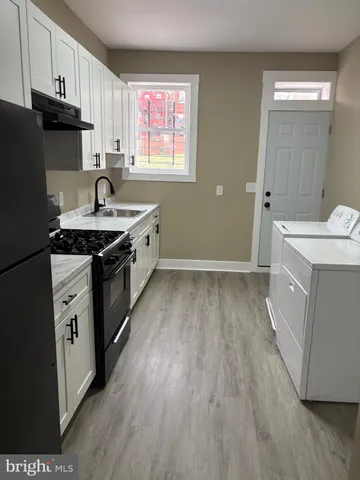 a kitchen with a sink stove top oven and cabinets