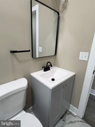 a white toilet sitting next to a bathroom sink