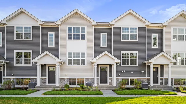 a front view of a house with yard and green space