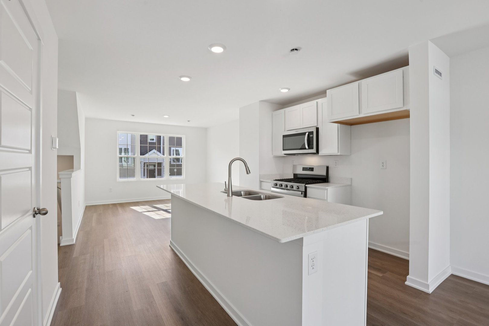 1403 Oakfield Lane Pingree Grove, IL 60140 - Photo 8 of 48 a view of a kitchen with kitchen island a sink wooden floor and a refrigerator