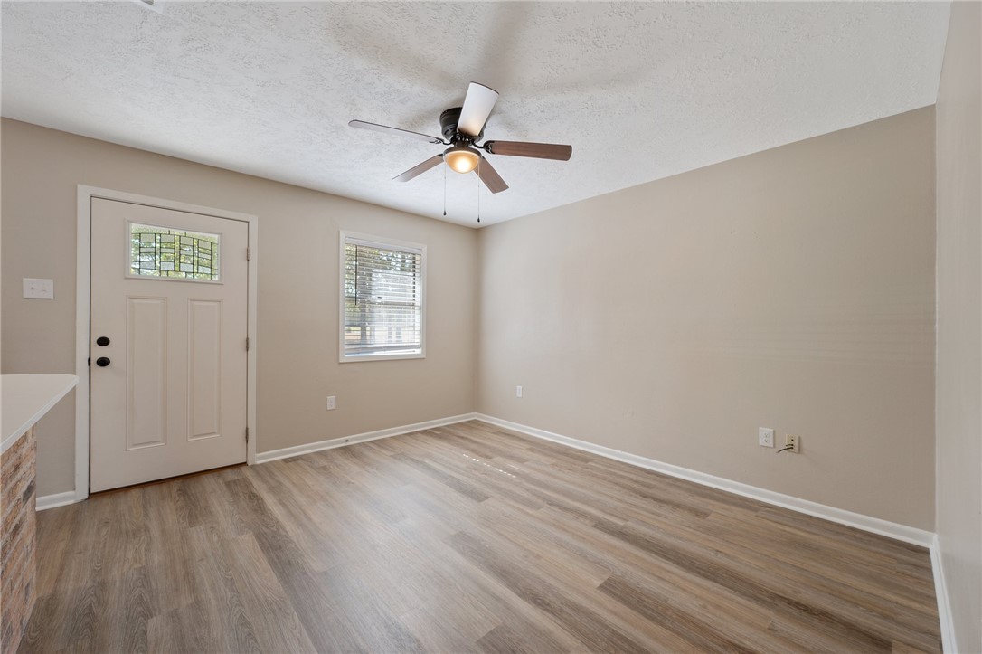 4950 Schehin Road College Station, TX 77845 - Photo 4 of 13 an empty room with wooden floor chandelier fan and windows