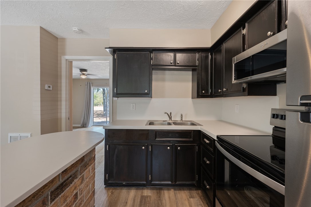 4950 Schehin Road College Station, TX 77845 - Photo 6 of 13 a kitchen with stainless steel appliances a sink stove and microwave