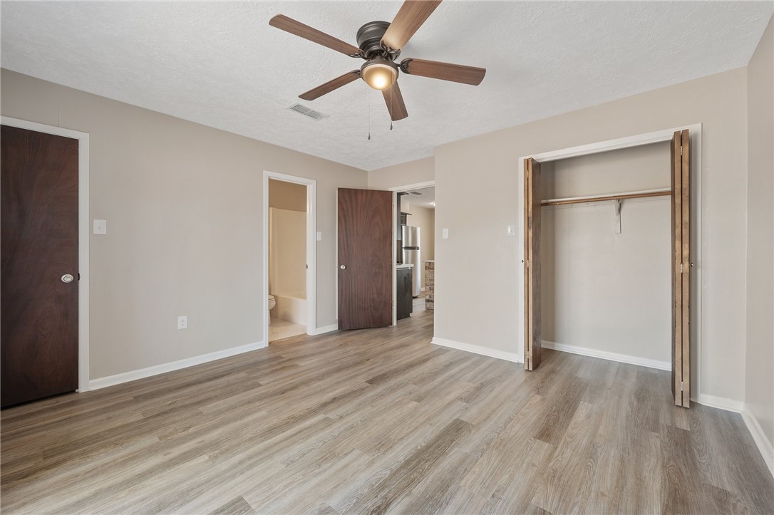 4950 Schehin Road College Station, TX 77845 - Photo 9 of 13 a view of an empty room with window a ceiling fan and wooden floor