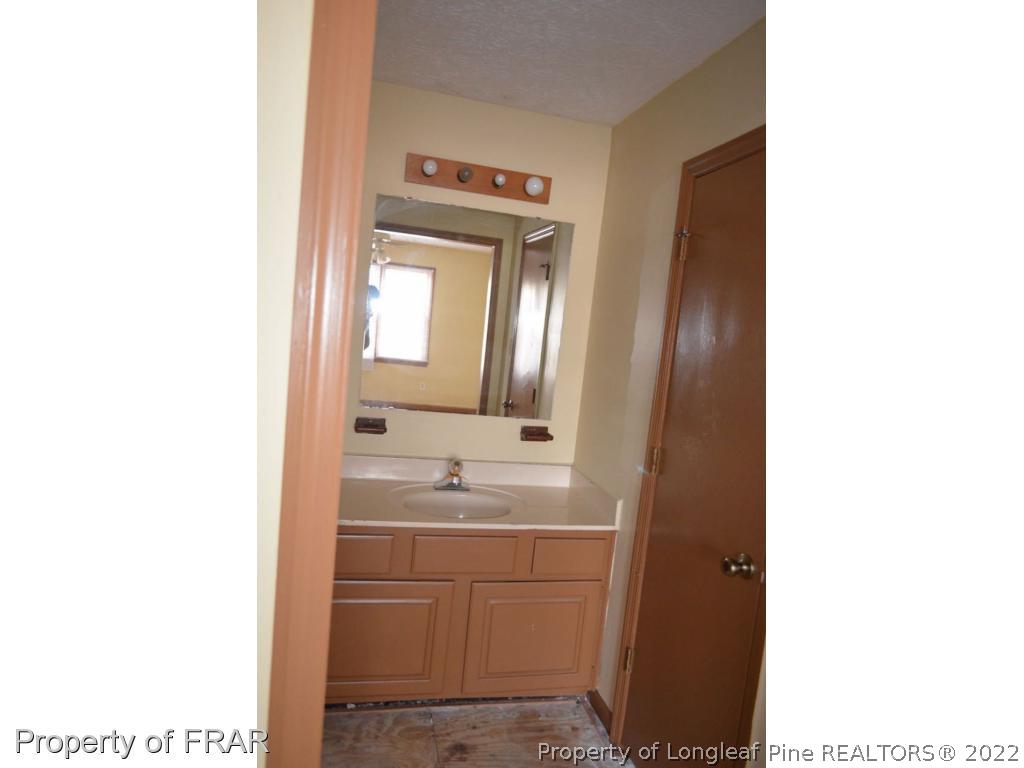 110 Bruce Lane Spring Lake, NC 28390 - Photo 11 of 21 a bathroom with a sink a toilet and mirror