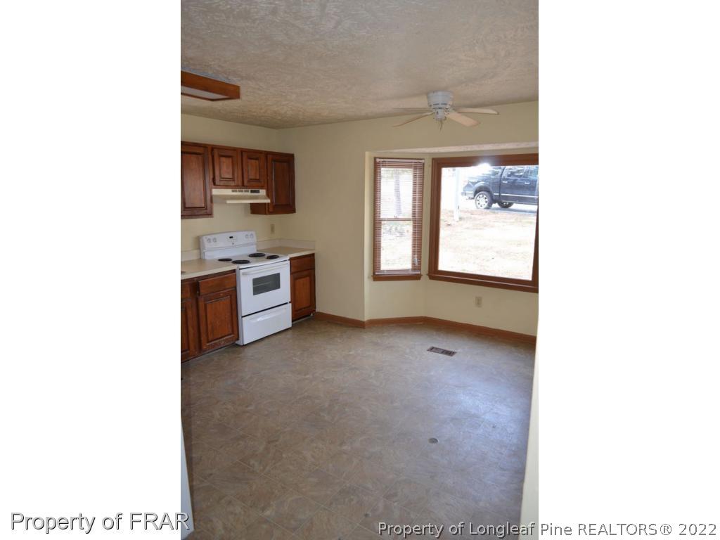 110 Bruce Lane Spring Lake, NC 28390 - Photo 7 of 21 a view of a kitchen and a sink and a living room with a chair