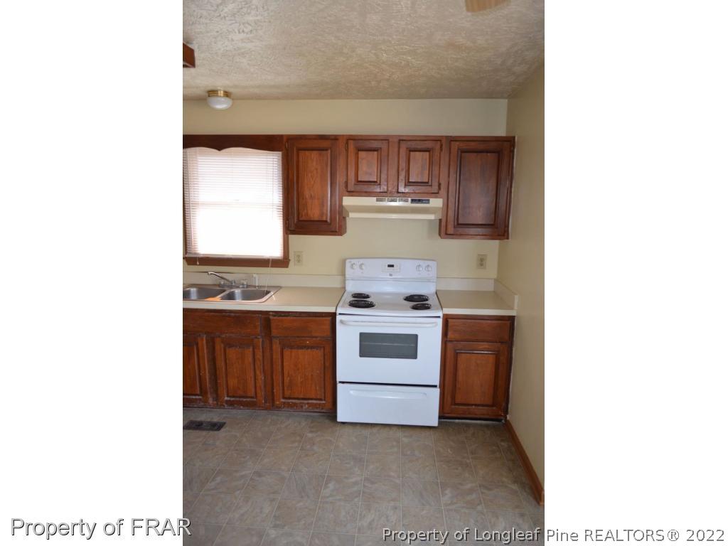 110 Bruce Lane Spring Lake, NC 28390 - Photo 9 of 21 a view of kitchen with sink cabinets and window