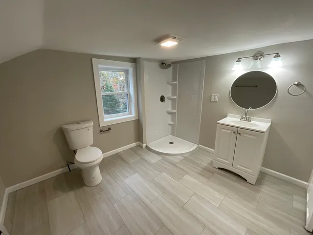 a bathroom with a sink mirror vanity and toilet