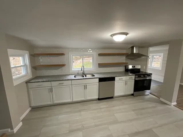 a large kitchen with a stove top oven and sink